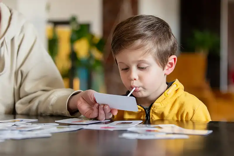 little boy learns words from cards under the aba therapy