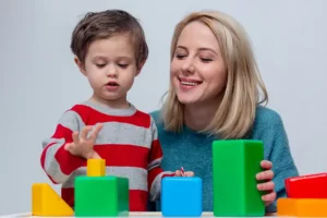 mother plays with her son in dice on the table