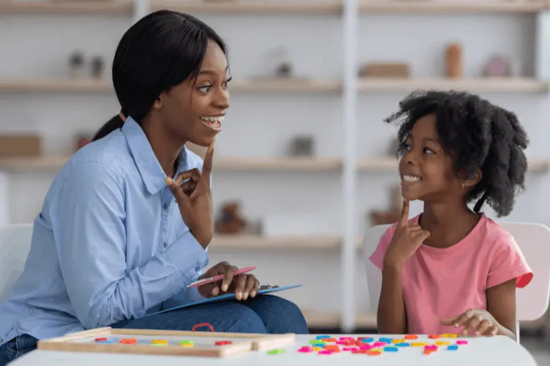 Behavior technician practicing communication skills with a child during ABA therapy